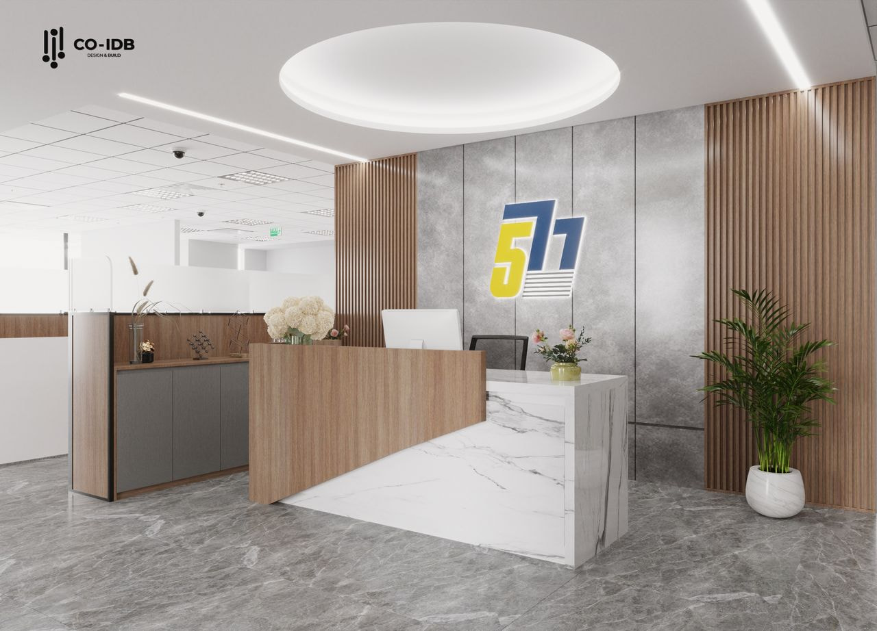 Toàn cảnh quầy lễ tân công ty 577 với thiết kế bất đối xứng tinh tế, tủ phụ kết hợp mặt đá và chậu cây xanh mang lại cảm giác cân bằng và gần gũi trong tổng thể sang trọng.