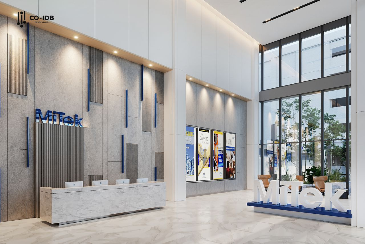 Sảnh lễ tân văn phòng Mitek với quầy đá trắng, tường ốp lam và không gian mở đón sáng.