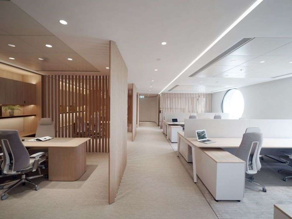 Văn phòng tối giản được thiết kế mở và ngăn cách với phòng quản lý bằng vách ngăn gỗ tạo sự phân chia nhẹ nhàng